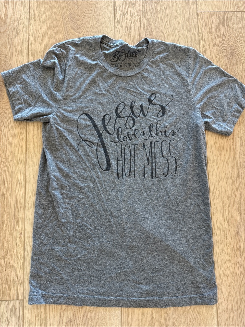 Be Still Boutique Gray Short Sleeve Tee with Black Script Graphic